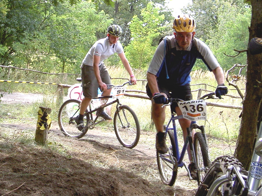 two men riding their bikes on a trail