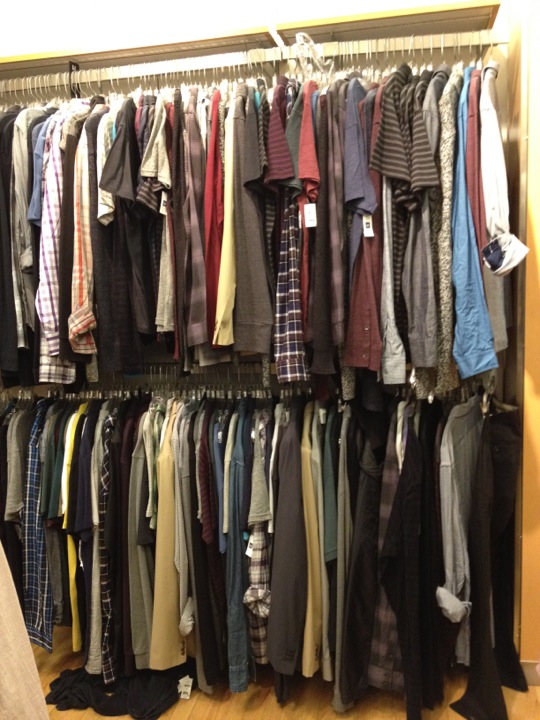 a clothes closet filled with lots of different shirts