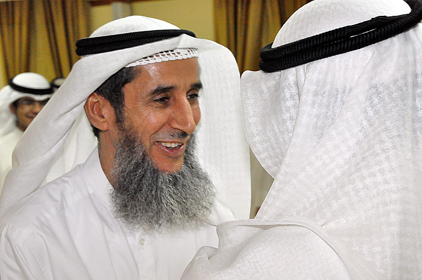 a smiling man wearing white is surrounded by many people