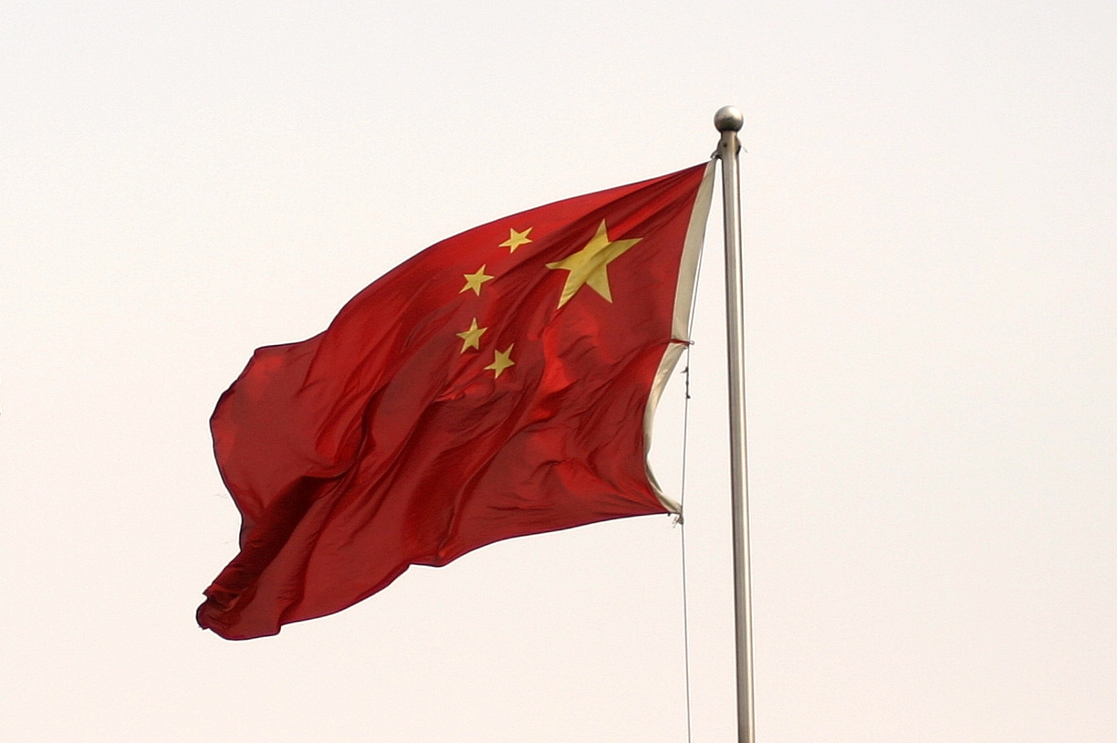 the chinese flag is flying in the clear sky