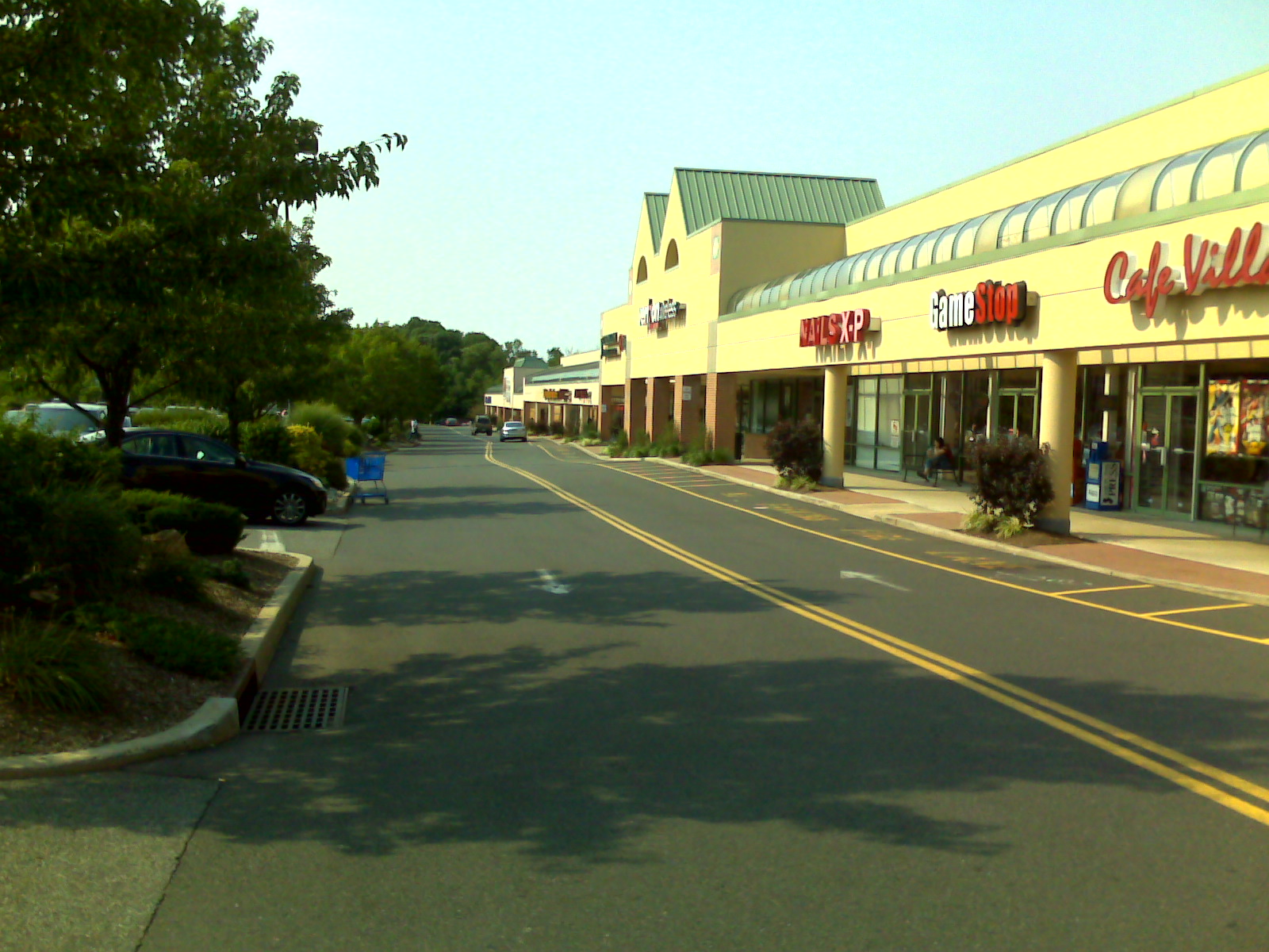 a parking lot with several stores on the sides of it