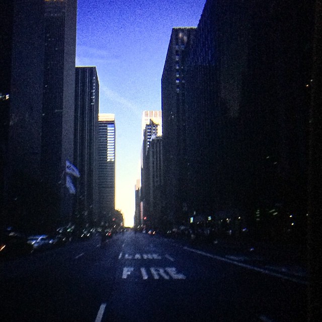 a street and tall buildings at night in a city