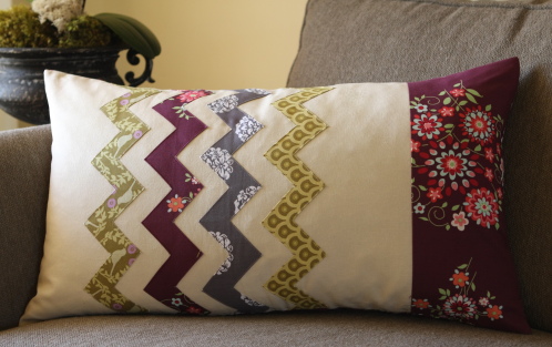 a decorative pillow sitting on top of a sofa