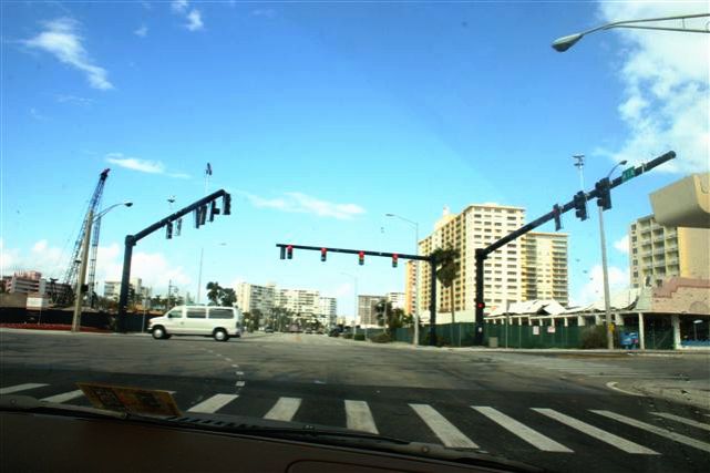 traffic lights in the street near a city with lots of tall buildings