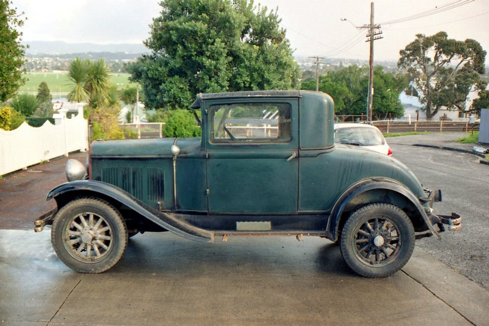 an antique truck is sitting parked in the street