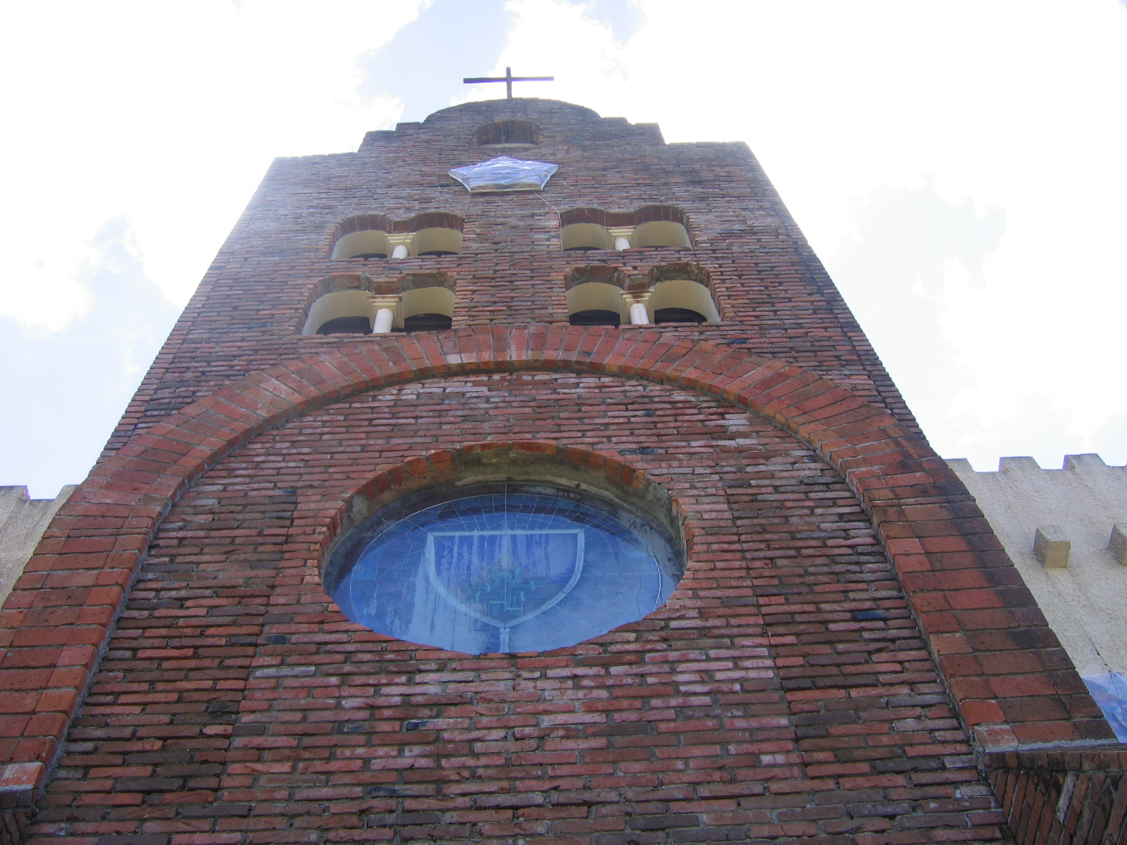 a large brick tower with a clock and a cross