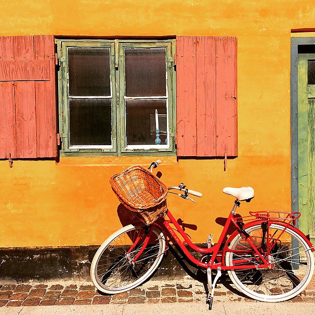 a red bicycle parked next to a building