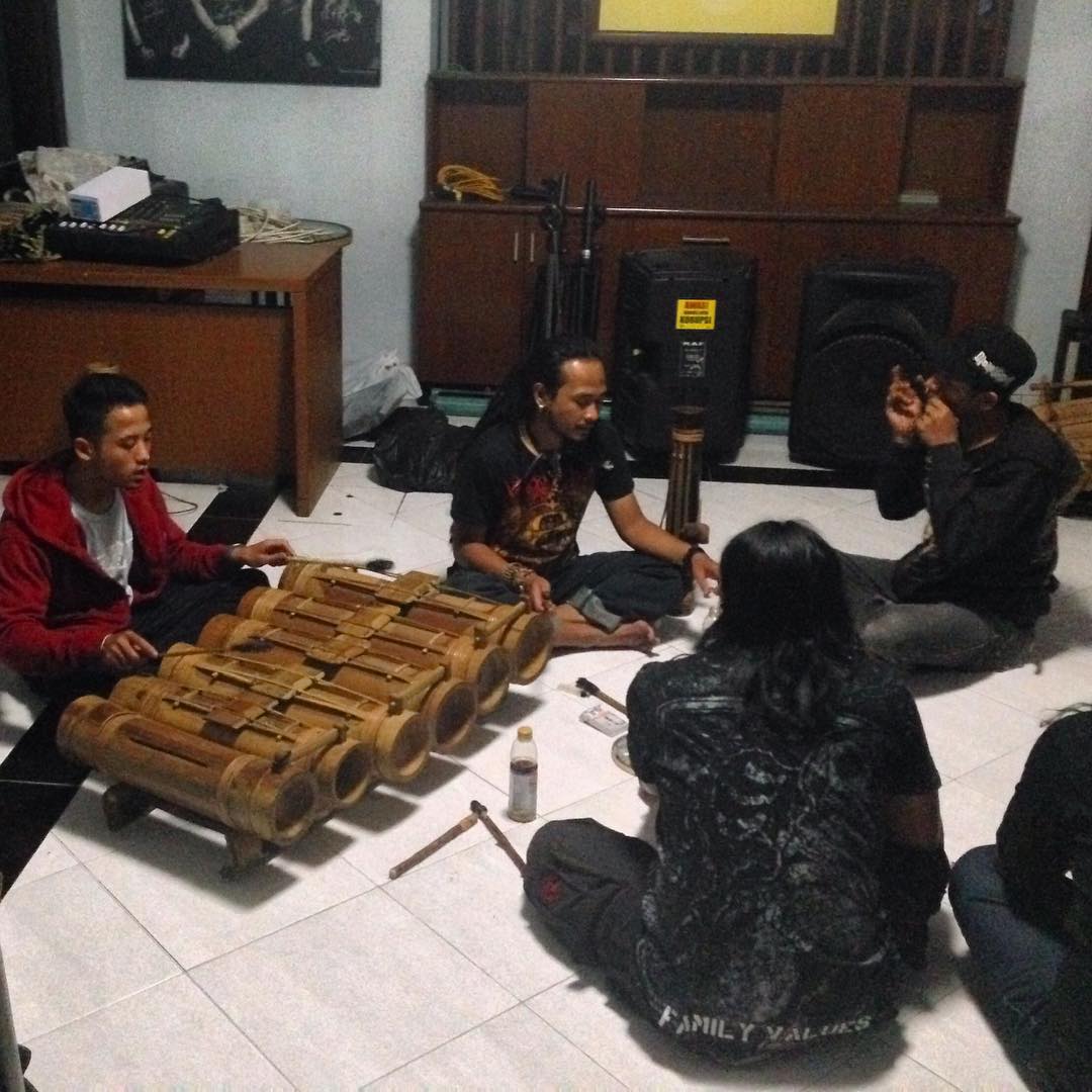 people playing with wooden objects on a tile floor