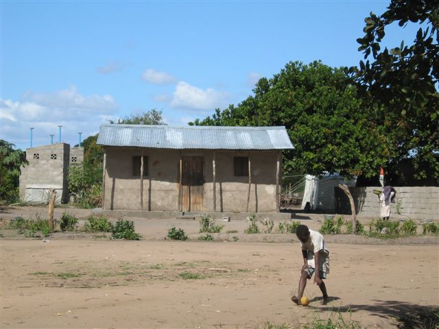 a person walking by a shack and a bicycle