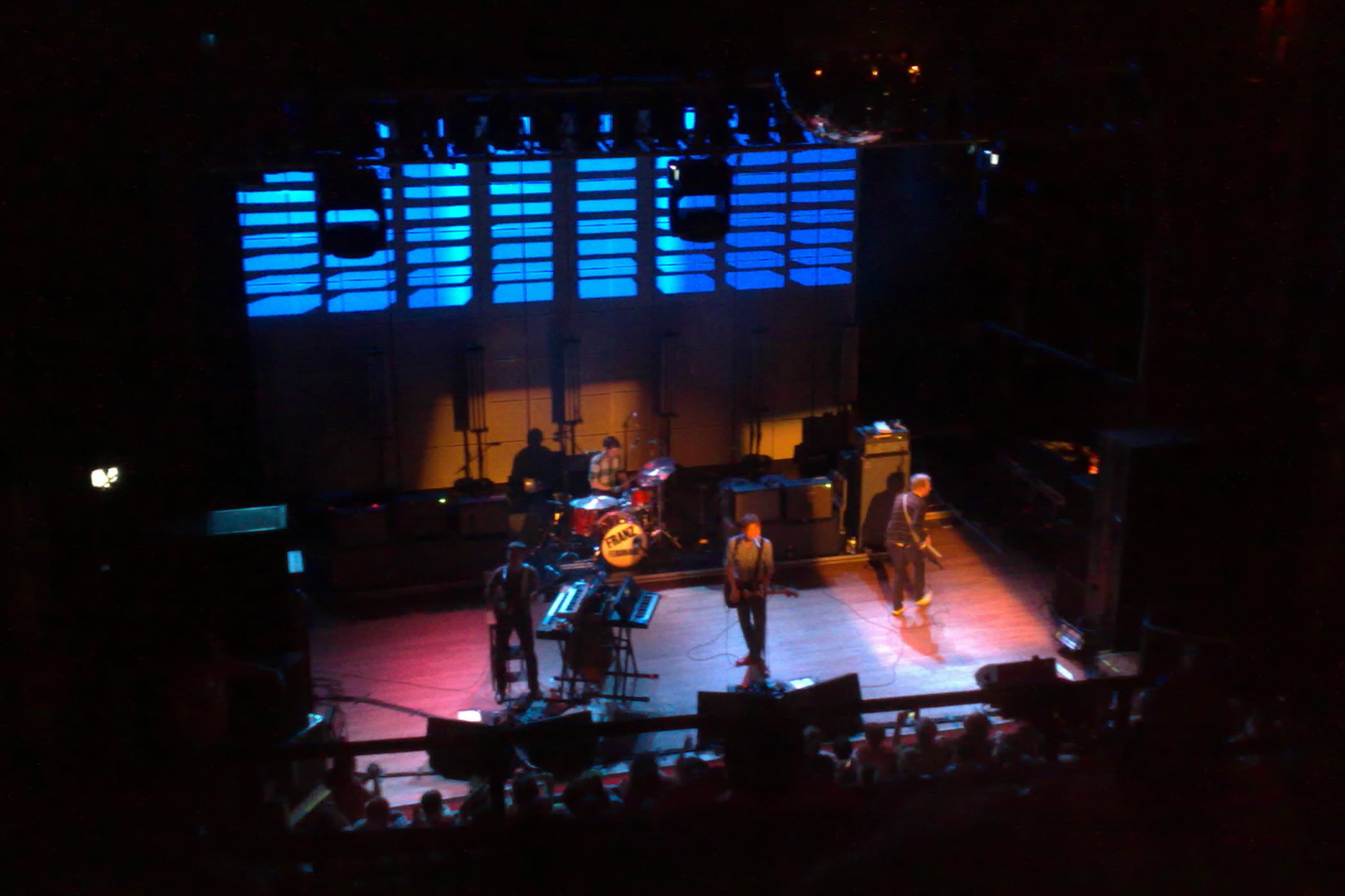 people stand on a stage under blue lights