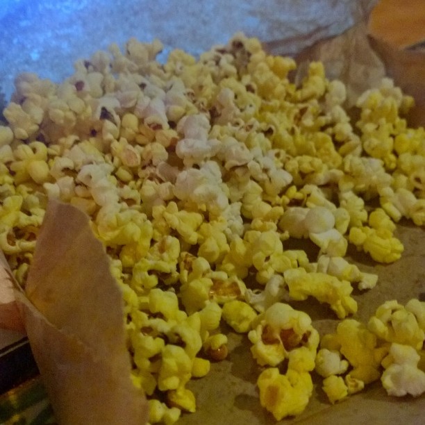 a piece of brown paper sitting on top of a pan filled with popcorn