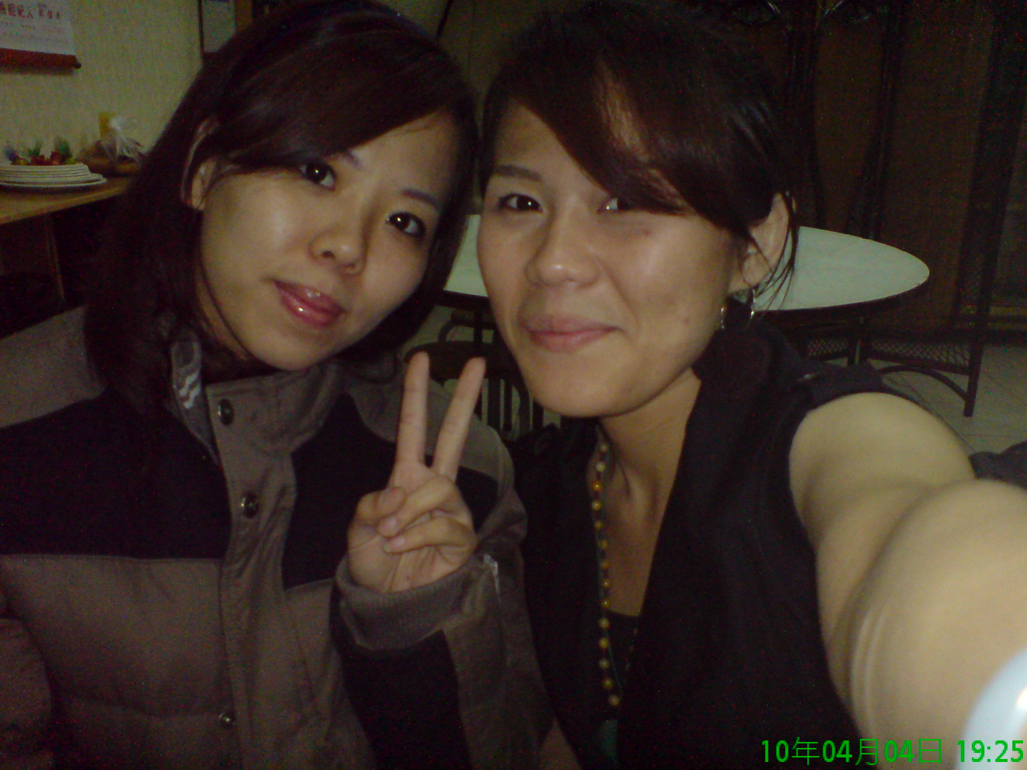 two women posing for a po together, one showing the peace sign