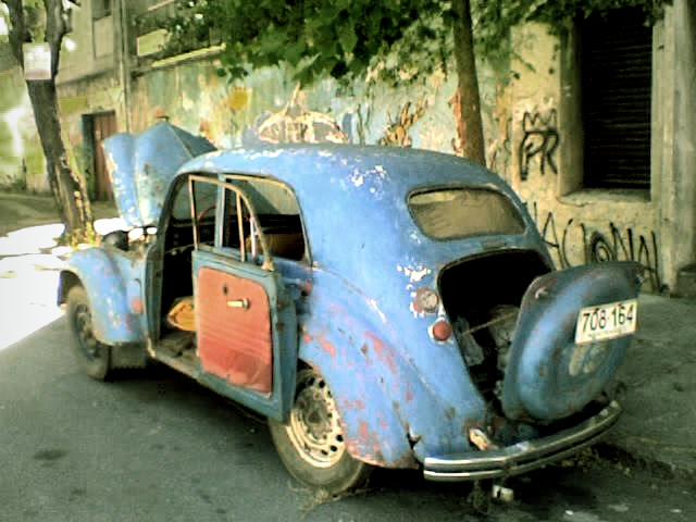 a old beetle sitting on the side of a road