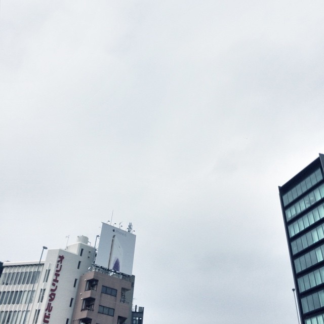 two tall buildings in front of some clouds