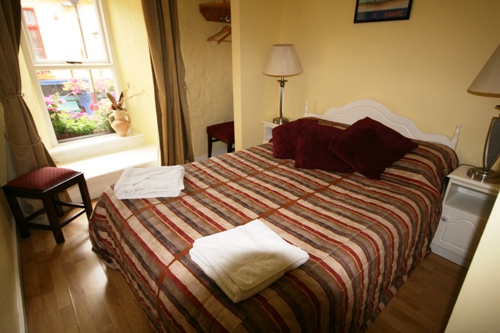 large bed with red pillows and blankets in el room