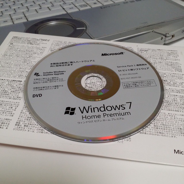 a window dvd sitting on a book that is next to a keyboard