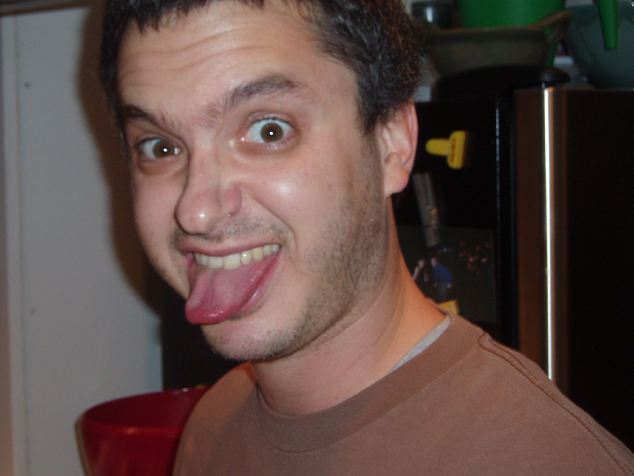 a young man sticking his tongue out with no teeth
