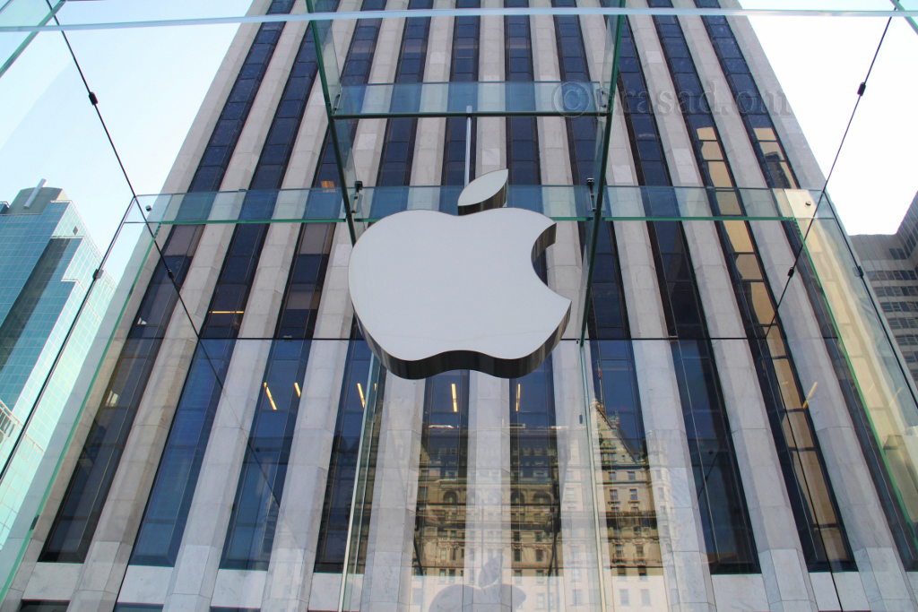 an apple sign in front of a large building