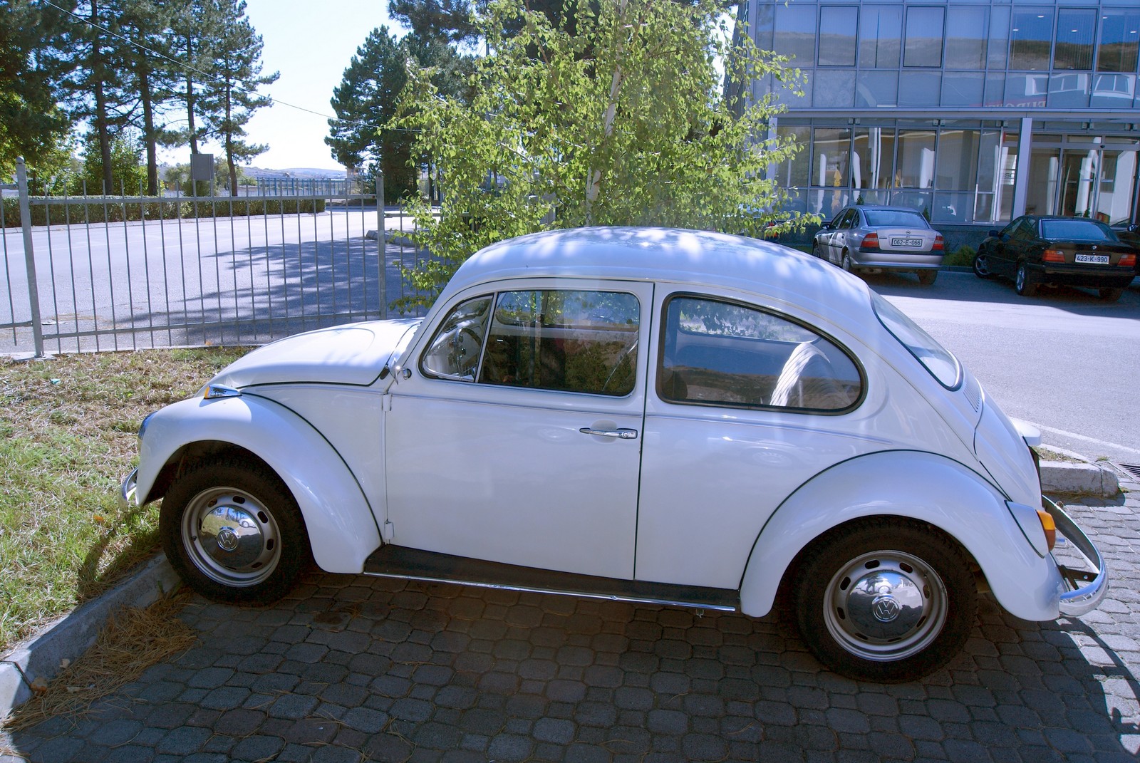 a white vw bug is parked on the street