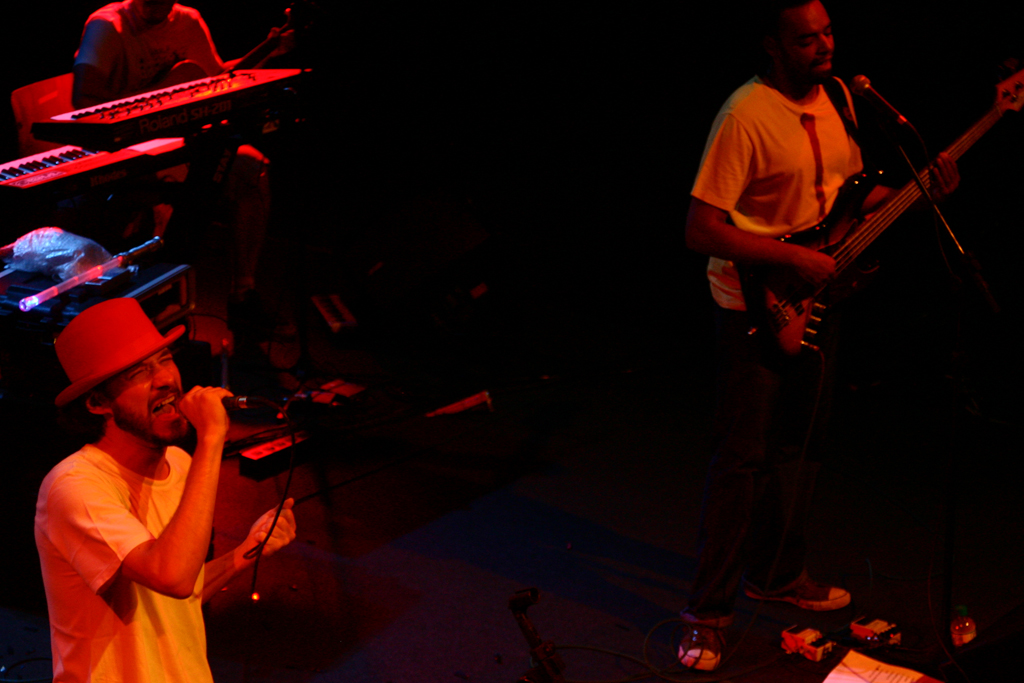 the musician and guitarist are performing together in a dark room