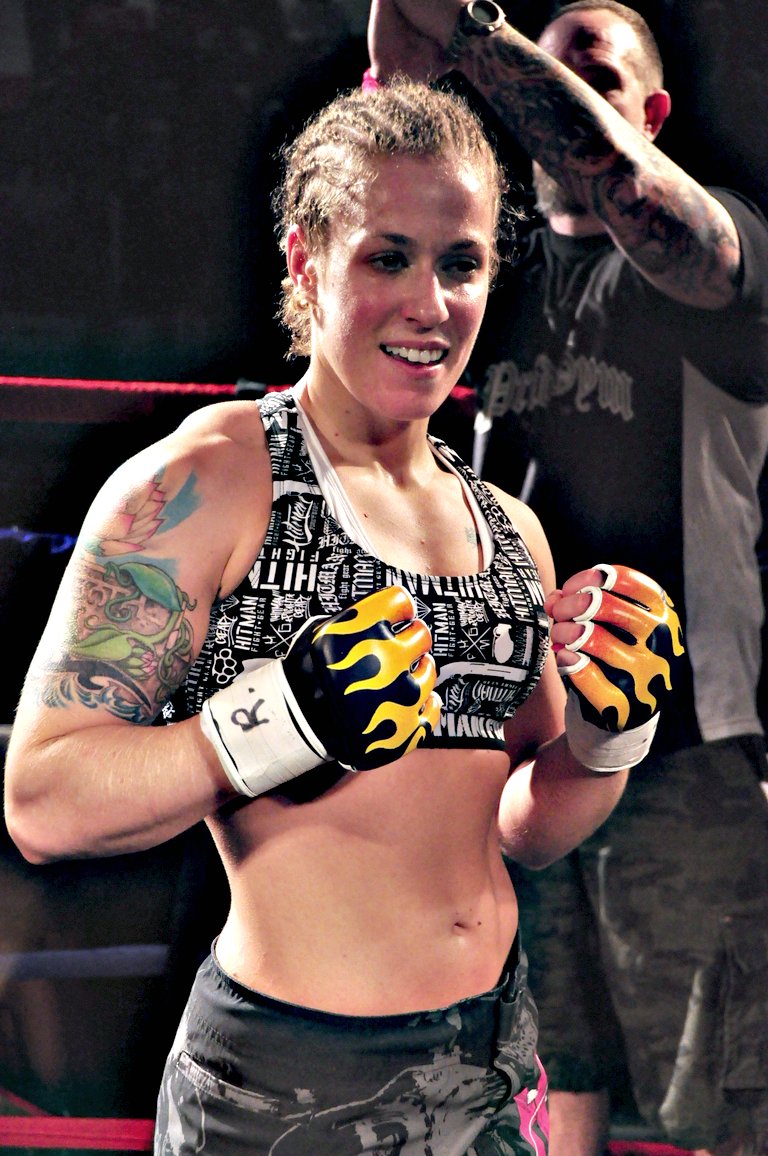 a female in a black top holding a boxing glove