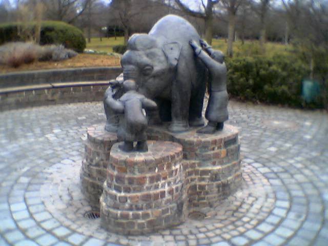 an elephant statue on top of a brick pedestal