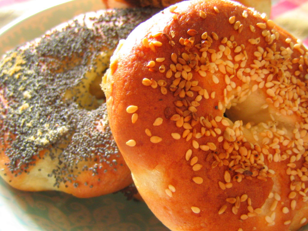 sesame seed bagels on a plate with other pastries