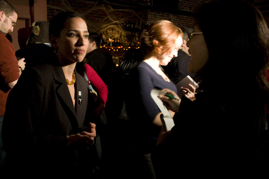 two women and one man standing in a room talking