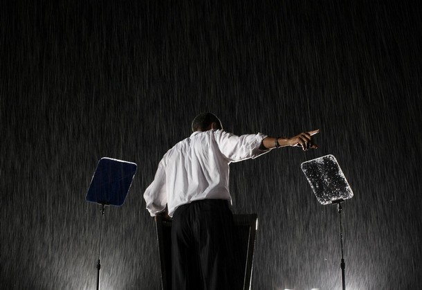 a man standing in the rain with his arm out