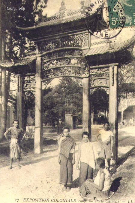 group of people in front of asian structure with trees and buildings