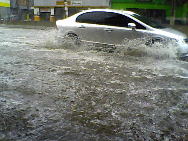 a car driving through floodwater onto the road