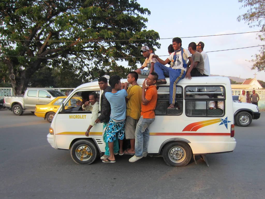a group of men riding on the top of a bus