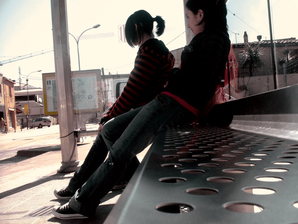 there are two young women sitting on a bench