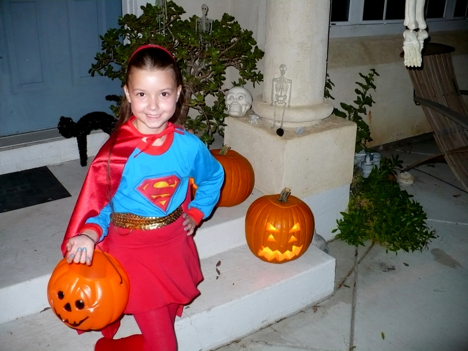 a little girl in a costume holding a pumpkin