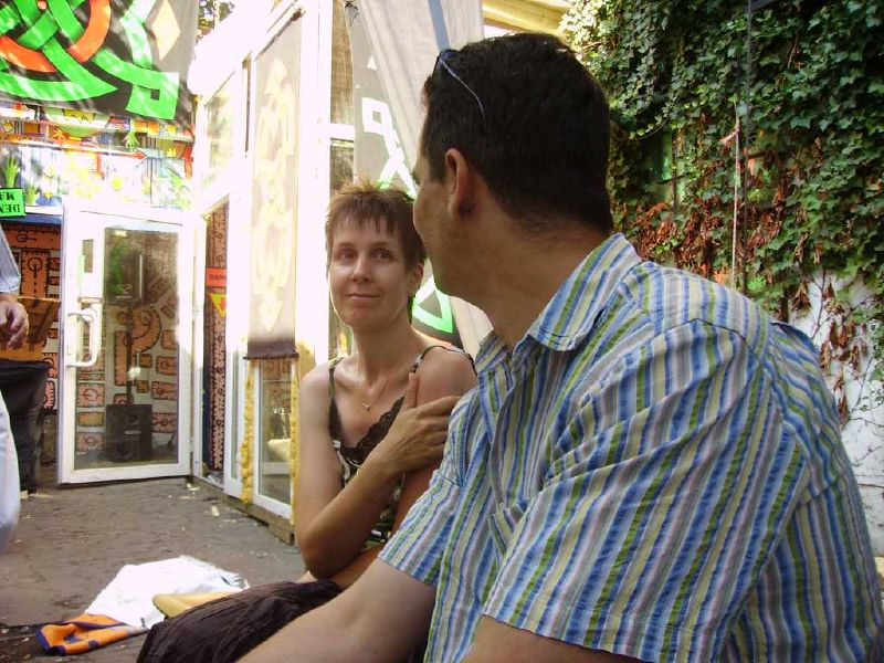 a woman brushing a mans hair outside