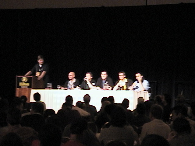 a panel of actors sitting on stage in front of a crowd