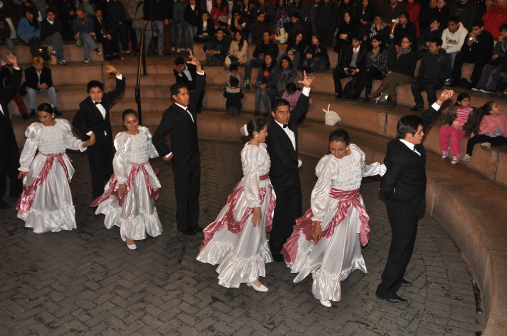 several people wearing long dresses are dancing in the street