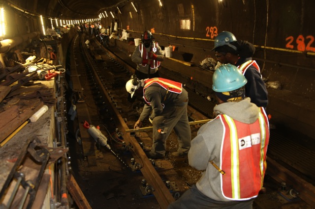 workers work on the track in a subway