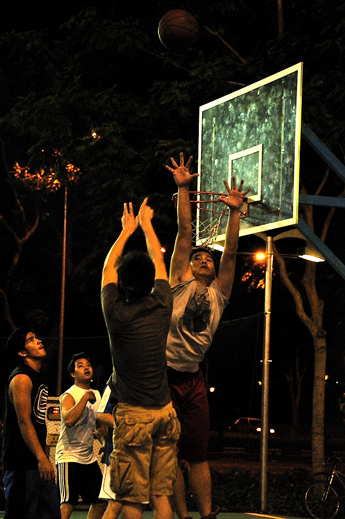 a group of people are playing basketball in the park