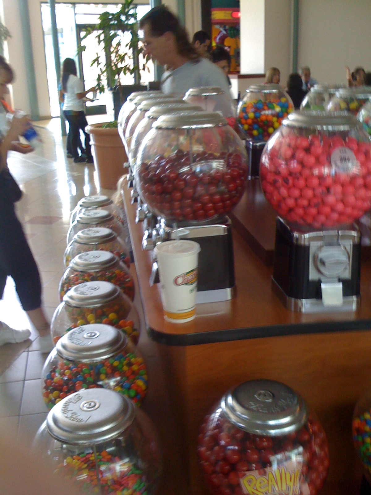 candy containers with colorful candies in them and people standing around