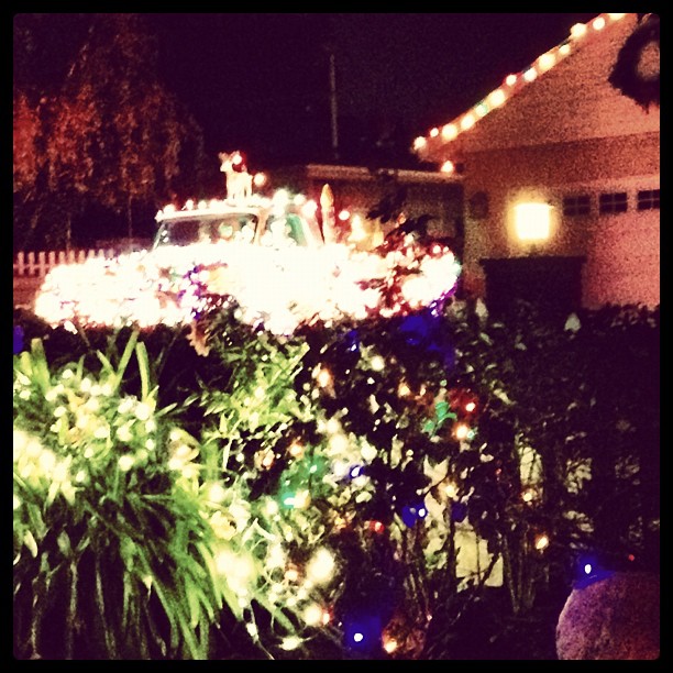 a lighted holiday truck sitting on top of a tree