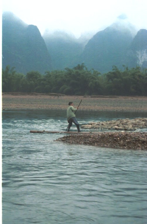 a man stands on an island holding a baseball bat and fishing