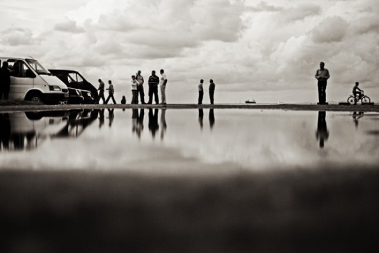 several people are standing around a van parked on a road