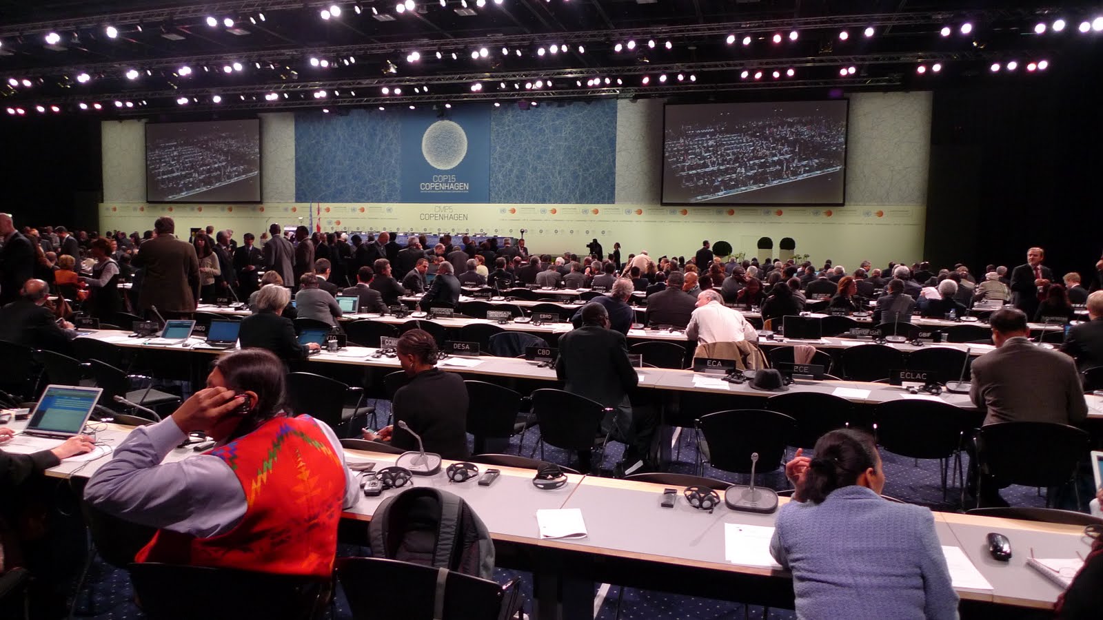 an auditorium filled with people in seats and a screen