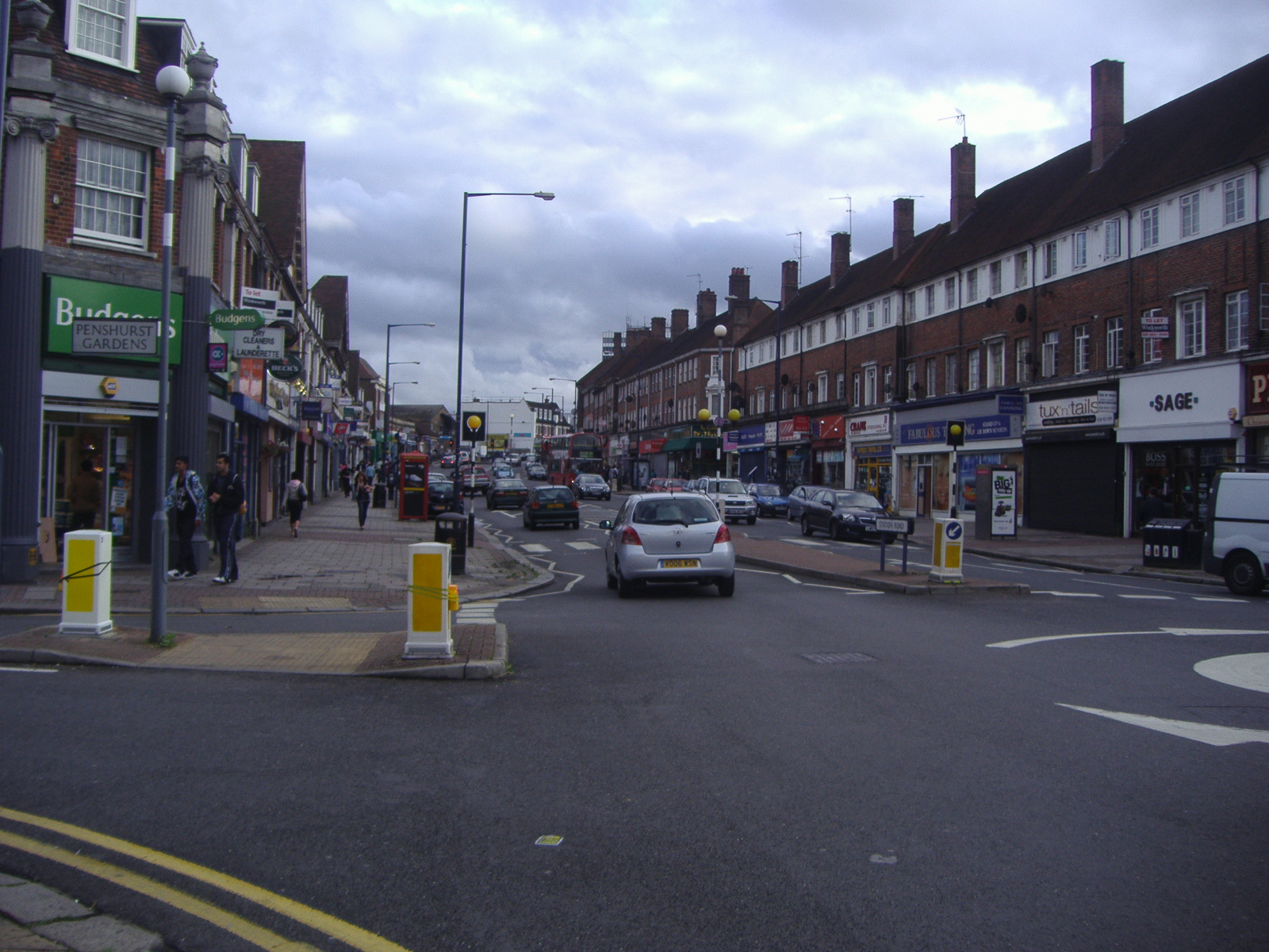 several cars on street with buildings in the background