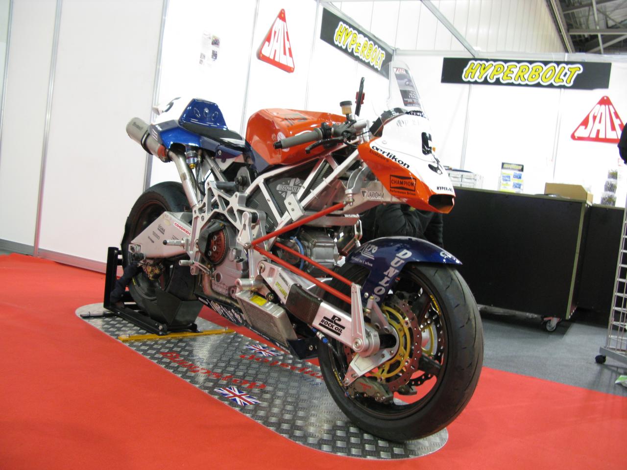 an orange and blue motorcycle on display in a building