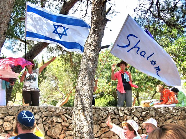 jewish and israeli flags blowing from trees near people