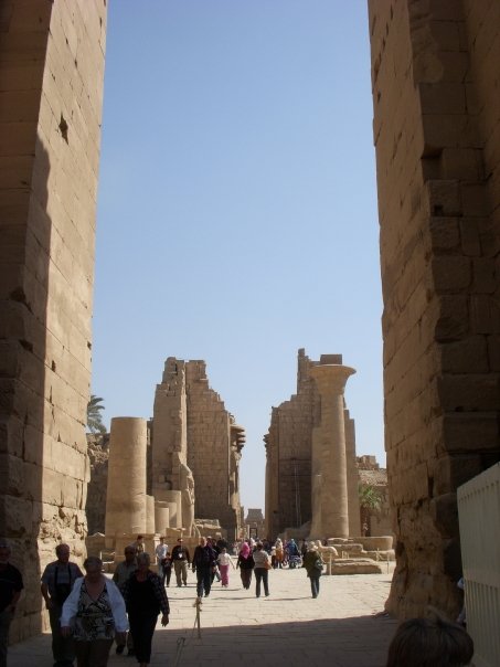 tourists entering ancient city from large arch