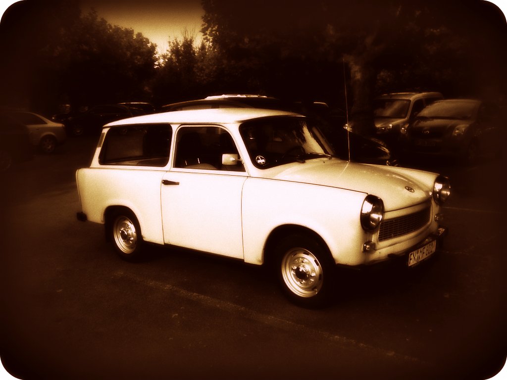 a old car sits in the lot near some other cars