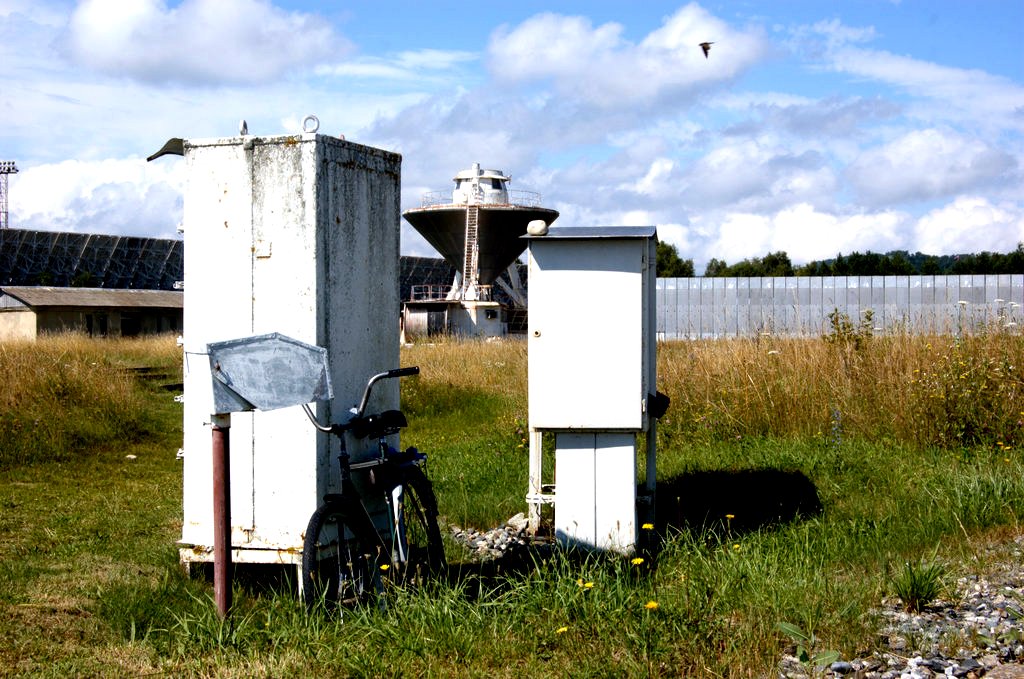 two beehives are standing in the grass next to a bike